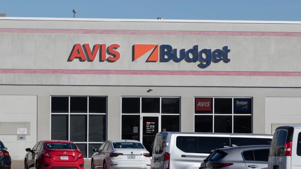 Rental cars lined up in front of an Avis-Budget storefront outlet.