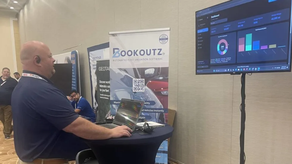 Bookoutz CEO demonstrating program on a laptop computer at a trade show.