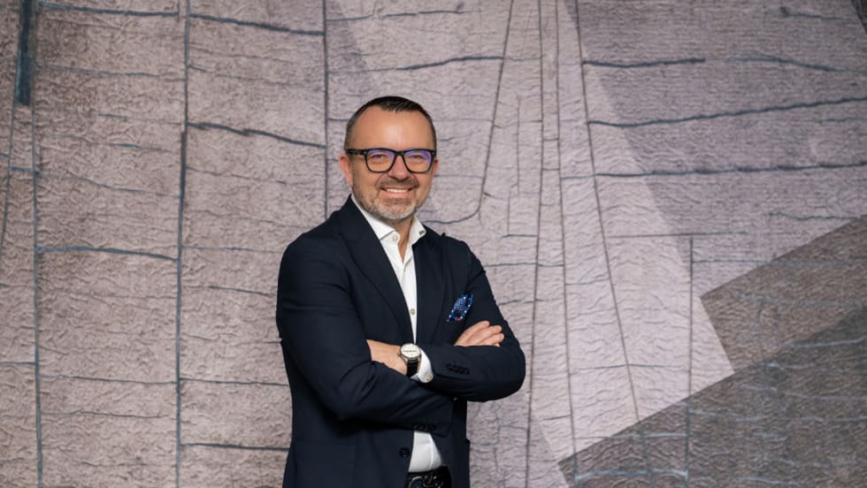 Photo of CEO Krešimir Dobrilović against a gray modernist crooked-tile mural display.