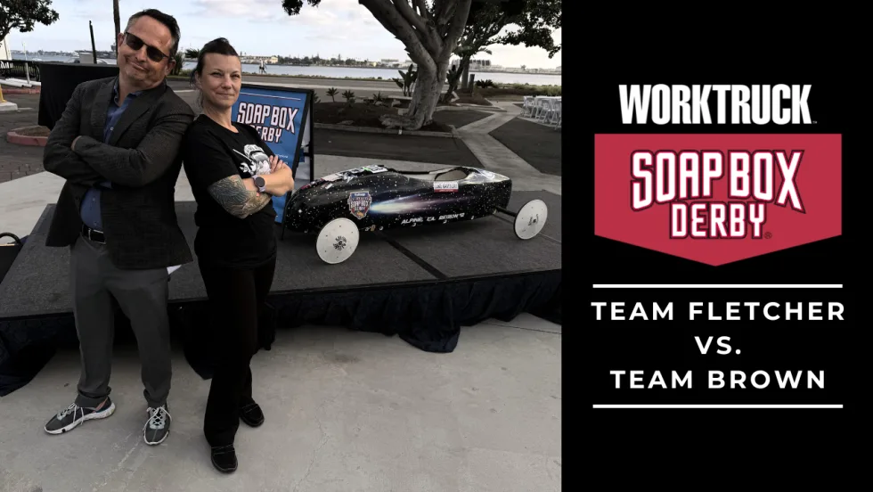 Chris Brown and Lauren Fletcher stand in front of Soap Box Derby race car for promotion of Soap Box Derby Corporate Challenge. 