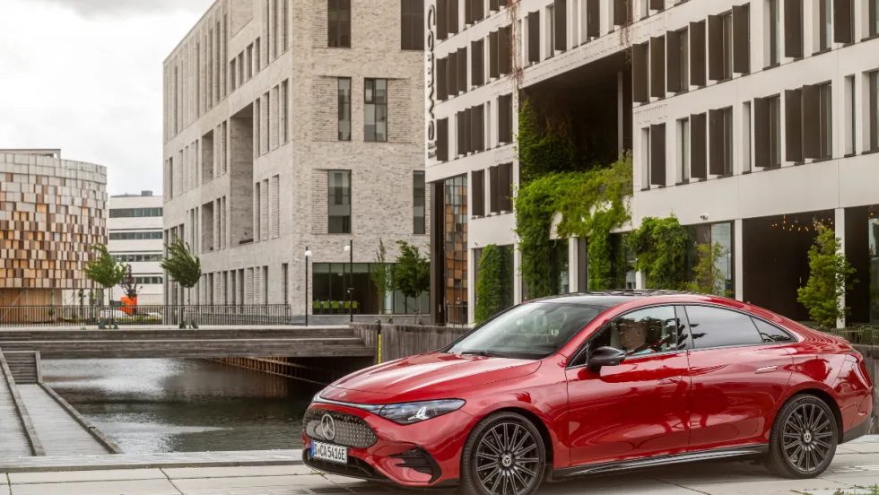 A 2026 electric Mercedes-Benz CLA sits in front of a tan building.