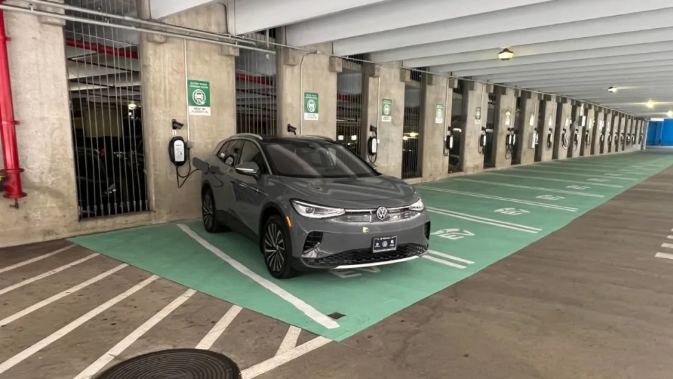 An electric vehicle gets charged along a line of EV chargers at the main airport in Honolulu, Hawaii.