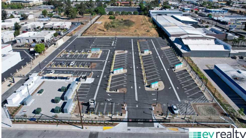 Aerial view of large EV truck charging hub in San Bernardino with multiple charging lanes and infrastructure for fleet vehicles.