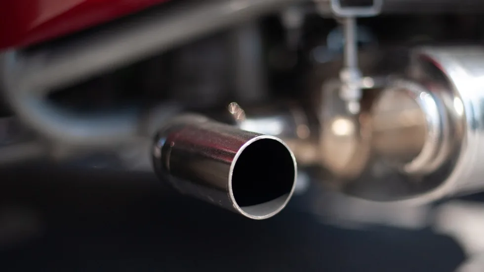 Photo of exhaust pipes of older car. 