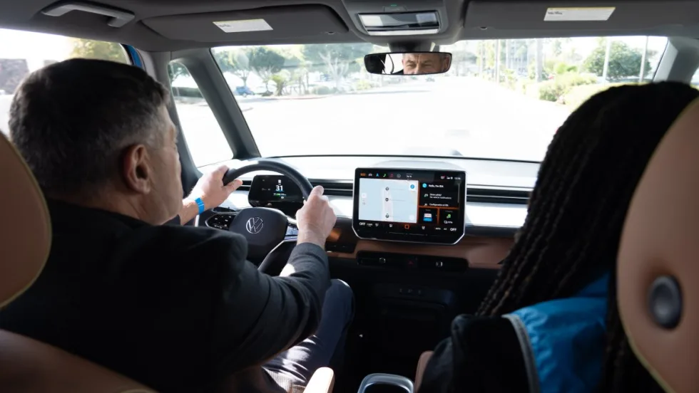 Interior shot of two people test driving a Volkswagen car.