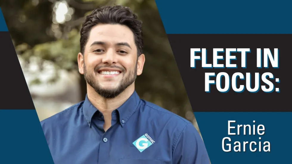 A man poses outside for a business portrait with a Gothic Landscape collared shit. The words "Fleet in Focus" are on the top right.