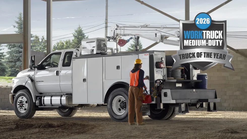 Ford F-650 or F-750 medium-duty work truck with service body and aerial lift at a jobsite with 2026 Work Truck Medium-Duty Truck of the Year badge.