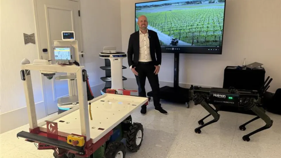 Joe Foster stands next to new Holman robotics managements solution tech.
