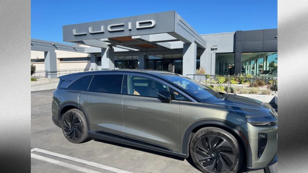 Lucid Gravity electric SUV parked outside a Lucid dealership, highlighting the company’s expanding EV lineup and plans for a new midsize platform and future mobility technologies.