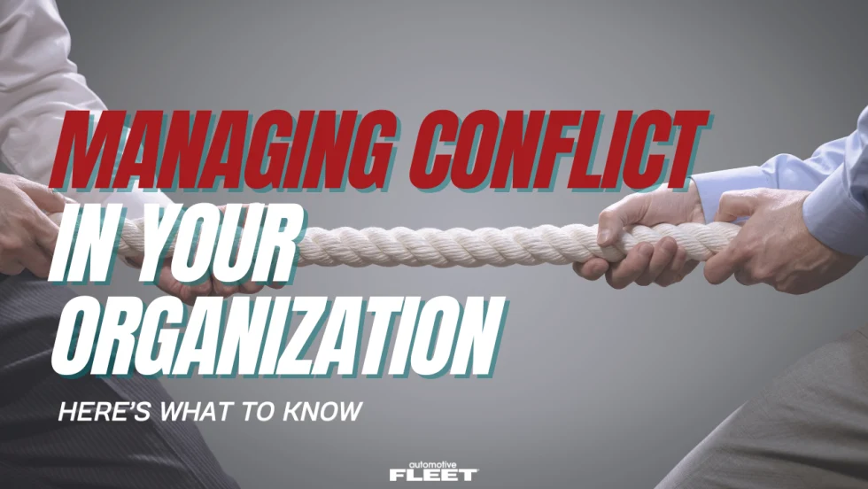 Two employees pull opposite ends of a rope in a tug-of-war, illustrating workplace conflict and the leadership strategies fleet organizations use to improve communication and teamwork.