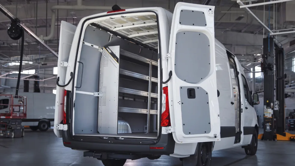 A Mercedes-Benz van with the back doors open.