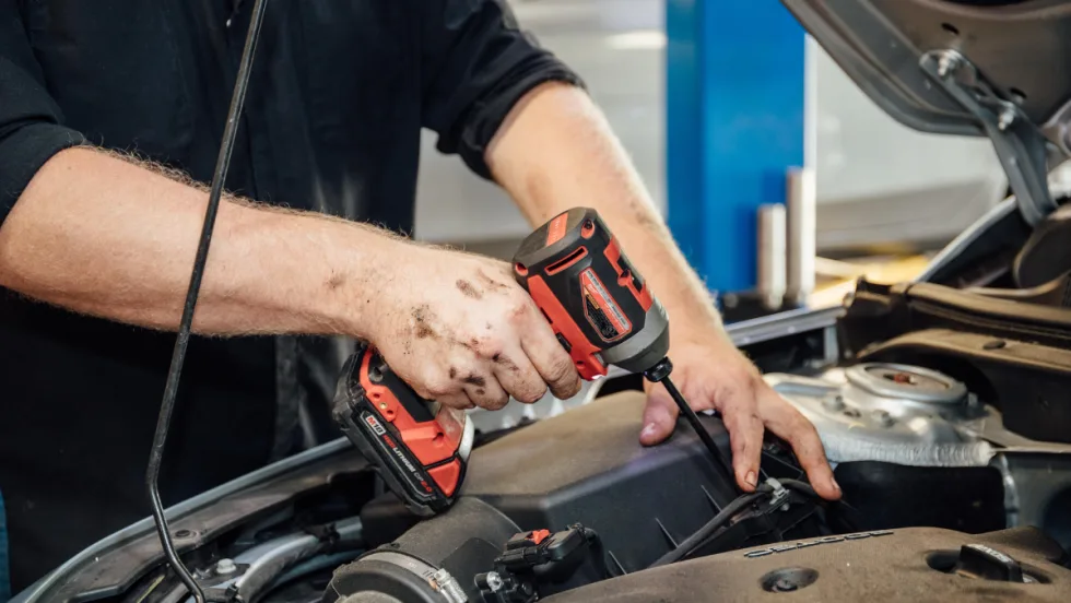 A technician working on a car engine.