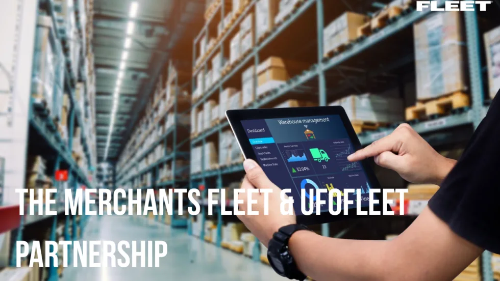 A fleet manager holds an iPad with displaying fleet information as he stands in a warehouse. 