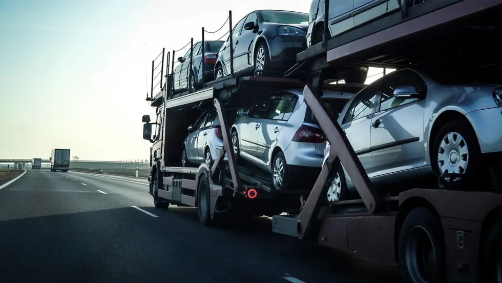 A double-decker stinger auto transporter loaded with new vehicles.