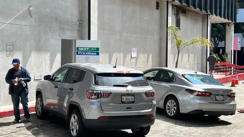 Two rental cars lined up at back entrance of NextCar Priceless rental car outlet near LAX.
