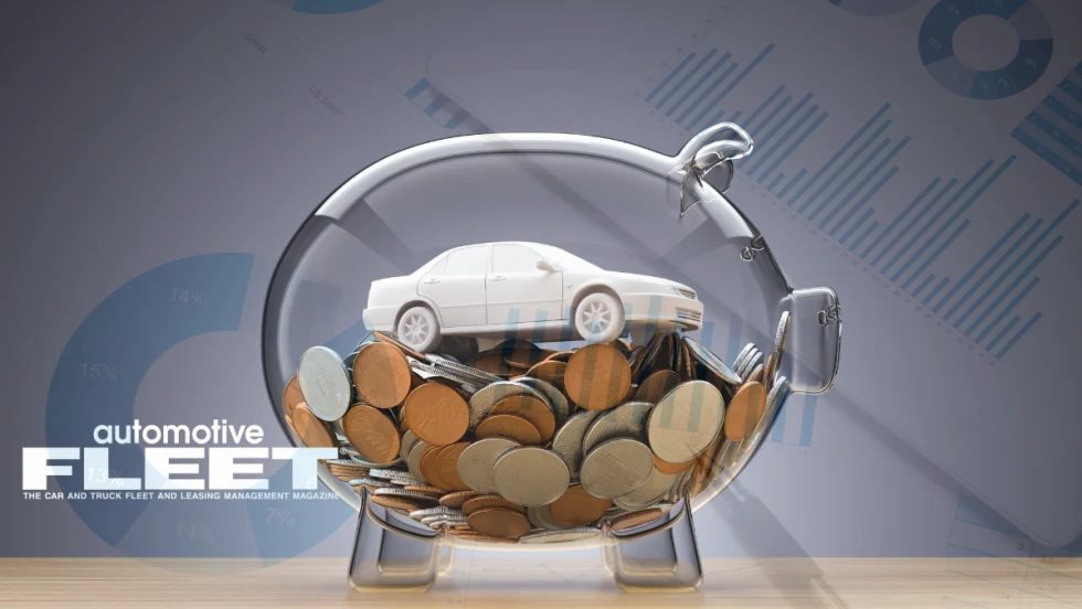 Photo of toy car in glass piggy bank.