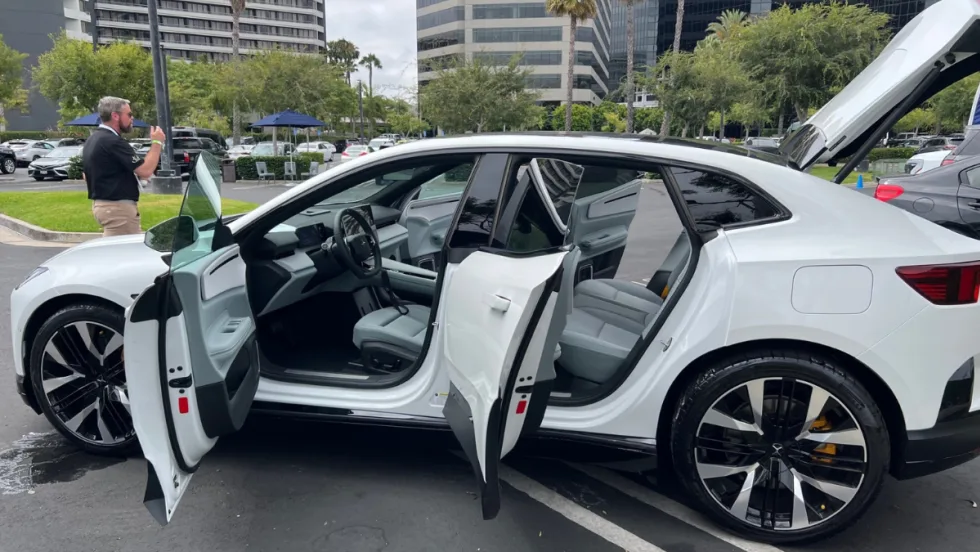  A white Polestar 3 with all doors and trunk lid open while on display at an EV sales event.