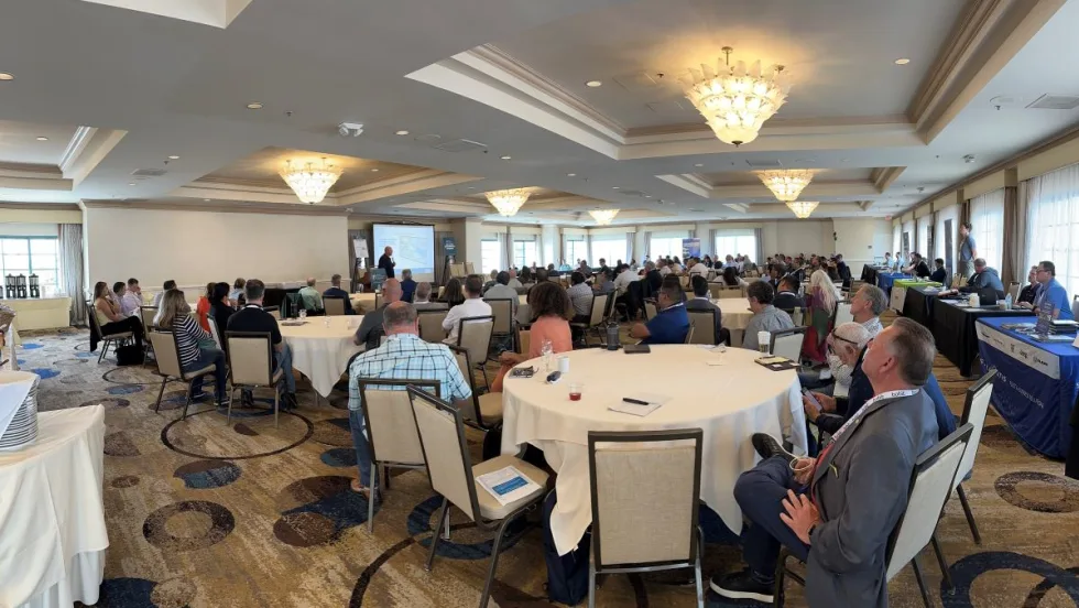 People in hotel conference room watching a speaker. 