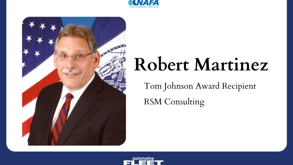 Portrait of Robert Martinez, Tom Johnson Award recipient and principal at RSM Consulting, wearing a suit and tie with a U.S. flag backdrop.