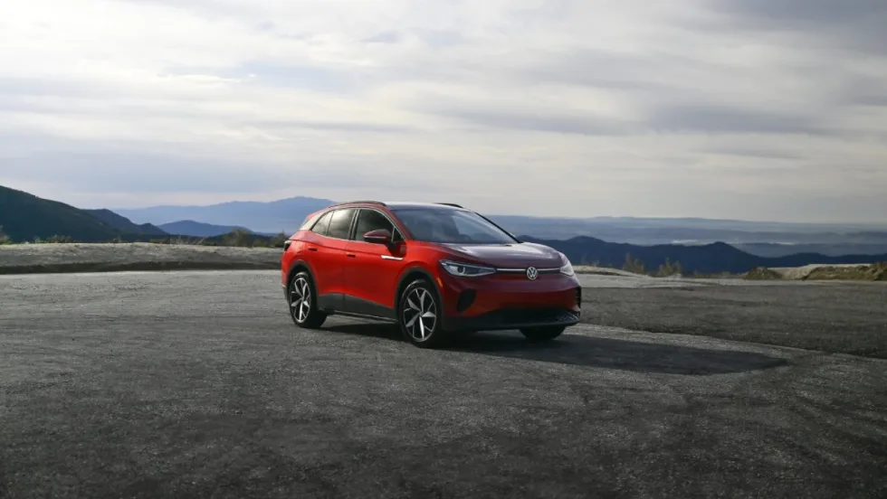 A red Volkswagen ID.4 with mountains on the horizon.