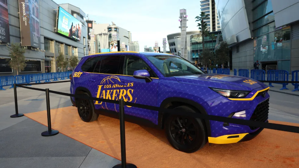 A purple and yellow wrapped Toyota Highlander with the L.A. Lakers logo parked in downtown.