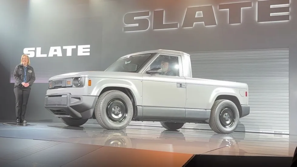 Woman on stage at product launch introducing electric truck. 