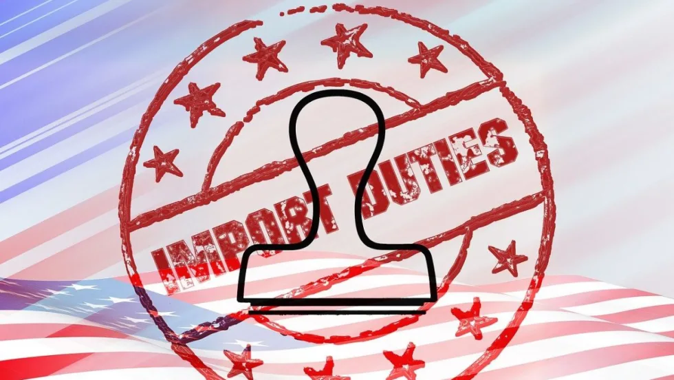 An import duties stamp and stamper superimposed on a flat American flag.