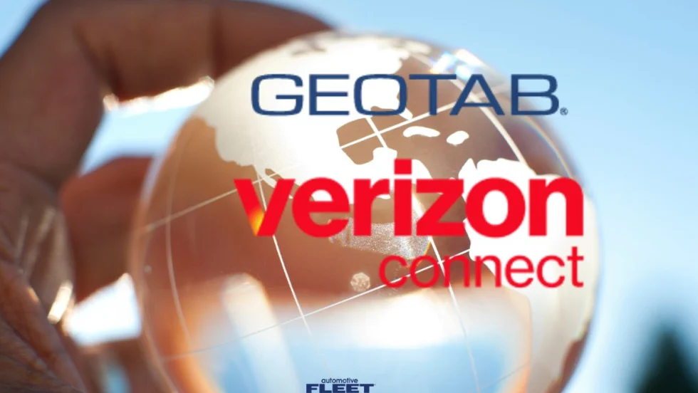 A hand holding a glass globe with the Geotab and Verizon Connect logos over them.