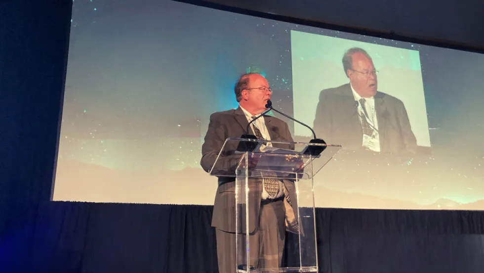 Photo of Mike Antich on stage addressing audience