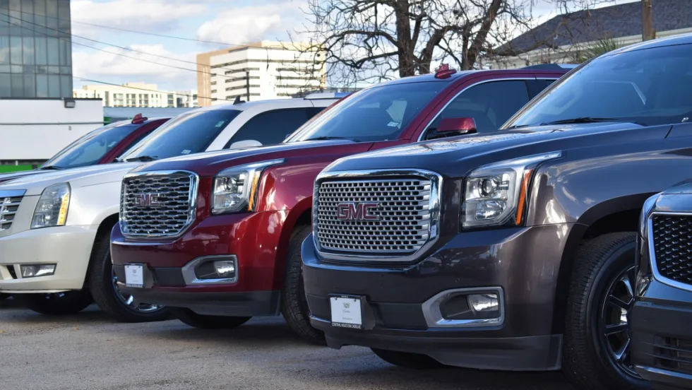 A row of GMC SUVs on a used car lot.