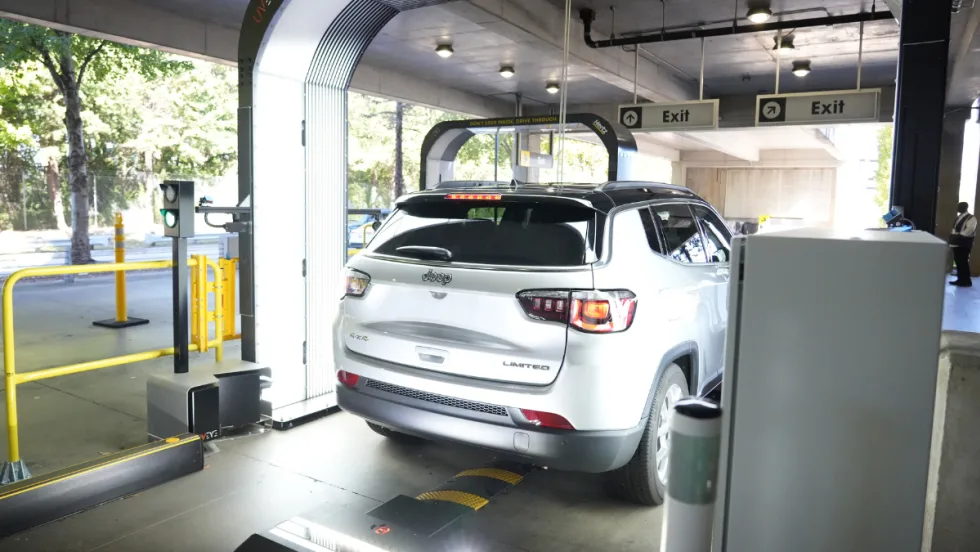 A rental car rolling through a UVeye overhead vehicle inspection terminal.