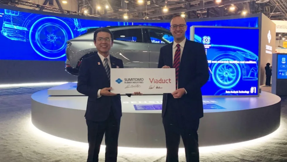 Two people pose with a sign symbolizing Viaduct's partnership with SRI.