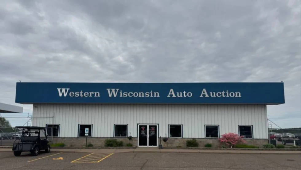 The front of the main building at Western Wisconsin Auto Auction on a cloudy day.