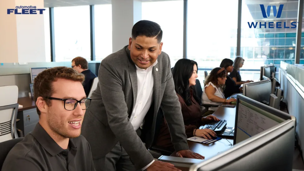 Hands typing on a laptop with AI graphics and rising data chart overlay, representing Wheels’ AI technology recognized with two 2026 AI Excellence Awards.