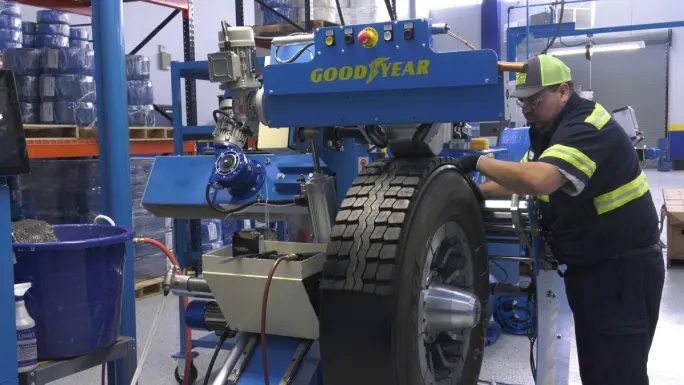 A technician working through the precure process on a retread tire