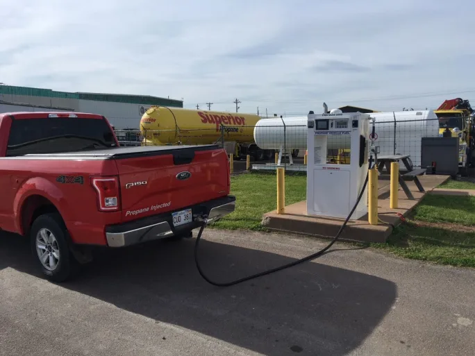 A red pickup truck being refueling with propane autogas