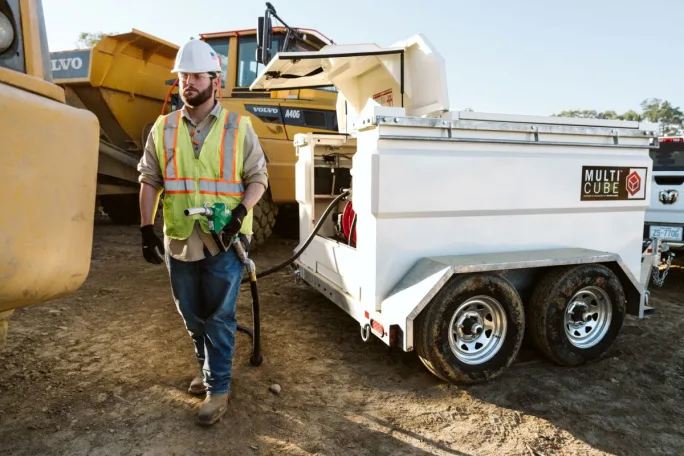 Construction worker fueling equipment from multicube.