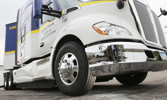 low angle photo of the front right tire on a tractor trailer