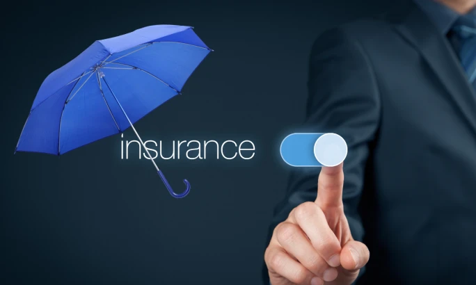 A business man touching the screen with insurance under an umbrella.