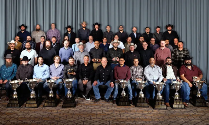 Group photo of winners with trophies and awards.
