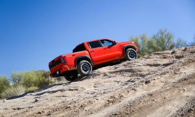 2026 Nissan Frontier PRO-4X in red climbing a steep rocky incline.