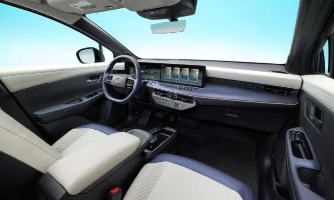 Interior view of the 2026 Nissan LEAF, showing the dashboard with dual displays and two-tone seating.