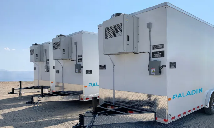 Row of white Paladin morgue trailers with refrigeration units, built by Acela to support emergency response.