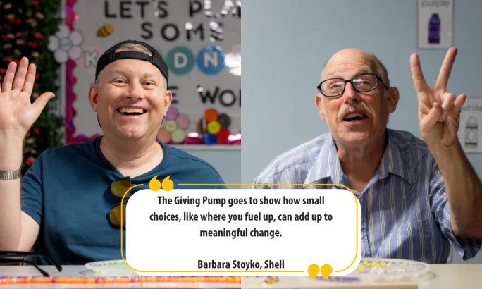 Two men from the MCDD program smiling and raising hands in celebration of Shell’s Giving Pump, a program supporting community charities across the U.S.
