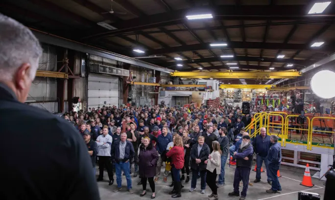 A large group of Stellar employees stand inside a company facility during an event celebrating the Employer of Choice award.