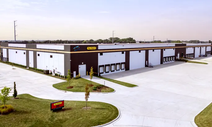 Exterior view of a commercial distribution center with PALFINGER name on one side.