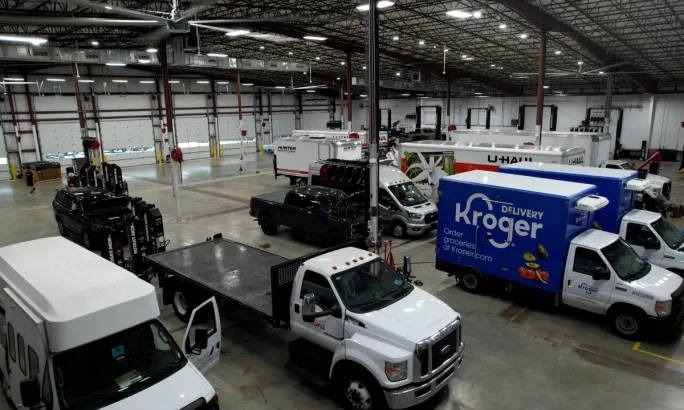Interior of a Ford Pro Elite Commercial Service Center with work trucks and vans inside large service bays.