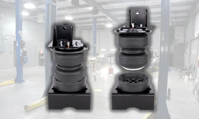 Two Air Lift LoadLifter 5000 Ultimate suspension components displayed in a service bay.