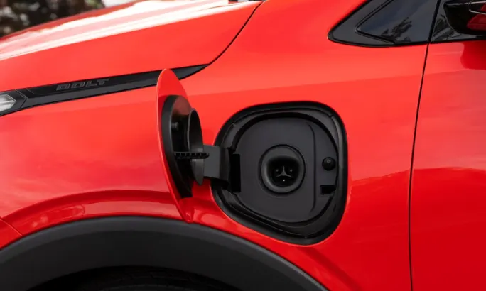 Close-up of charging port on red Chevrolet Bolt showing native NACS connector.