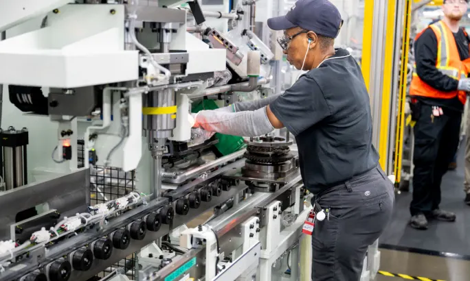 Toyota Alabama employee using automated machinery during differential assembly process in Huntsville plant.